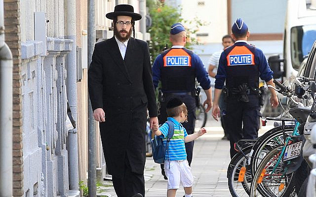 Un Juif orthodoxe et un enfant passent à côté de deux officiers de police à Antwerp, en Belgique, le 25 mai 2014. (AP Photo / Yves Logghe) Un Juif orthodoxe et un enfant passent à côté de deux officiers de police à Antwerp, en Belgique, le 25 mai 2014. (AP Photo / Yves Logghe)