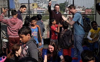 Des participants au programme du grand rabbin britannique Ben Azzai jouent avec des orphelins indiens lors d'un voyage à Kolkata en décembre 2018. (Judah Ari Gross/Times of Israël)
