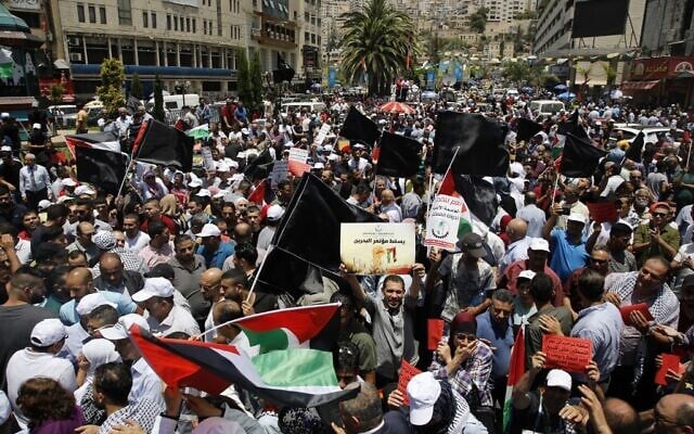 Des manifestants palestiniens brandissent des banderoles et des drapeaux nationaux lors d'une manifestation contre la conférence économique du Moyen Orient parrainée par les États-Unis qui s'est ouverte à Bahreïn, dans la ville de Naplouse, en Cisjordanie, le 25 juin 2019. (Jaafar Ashtiyeh/AFP) Des manifestants palestiniens brandissent des banderoles et des drapeaux nationaux lors d'une manifestation contre la conférence économique du Moyen Orient parrainée par les États-Unis qui s'est ouverte à Bahreïn, dans la ville de Naplouse, en Cisjordanie, le 25 juin 2019. (Jaafar Ashtiyeh/AFP)