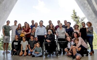 Melpomeni Dina (C), Juste parmi les Nations lors de la Seconde Guerre mondiale, pose pour une photo de groupe avec les survivants de la Shoah Yossi Mor (Cg et sa soeur Sarah Yanai (Cd), qu'elle a aidé à sauver en 1943, ainsi que leurs descendants dans la Salle des noms au Mémorial de l'Holocauste Yad Vashem à Jérusalem, le 3 novembre 2019. (Emmanuel DUNAND / AFP)