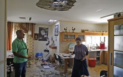 Des Israéliens inspectent une maison détruite par une roquette, à Sdérot, le 12 novembre 2019. (Crédit : MENAHEM KAHANA / AFP)