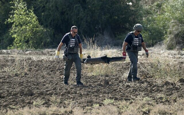 Des démineurs de la police israéliens enlèvent un débris de roquette tirée depuis Gaza, à Kiryat Gat, le 12 novembre 2019. (Crédit : Ahmad GHARABLI / AFP)