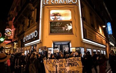 Des manifestants brandissent des pancartes et autres lors de protestations contre le réalisateur franco-polonais Roman Polanski devant le cinéma "Le Champo" à Paris, le 12 novembre 2019. (Crédit: Christophe ARCHAMBAULT / AFP)