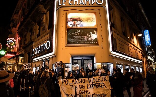 Des manifestants brandissent des pancartes et autres lors de protestations contre le réalisateur franco-polonais Roman Polanski devant le cinéma "Le Champo" à Paris, le 12 novembre 2019. (Crédit: Christophe ARCHAMBAULT / AFP)