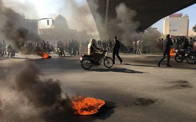 Des manifestants iraniens incendient des pneus pendant une manifestation contre la hausse des prix du carburant, à Ispahan, le 16 novembre 2019. (Crédit : AFP)