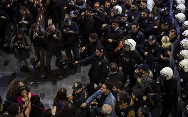 Un officier de police est en possession d'une arme à main non meurtrière alors que la police anti-émeute bloque l'accès de la ville alors que des militantes des droits des femmes participent à une marche sur la place Taksim à Istanbul le 25 novembre 2019 pour protester contre la violence sexiste à l'occasion de la Journée internationale pour l'élimination de la violence contre les femmes. (Crédit : Yasin AKGUL / AFP)