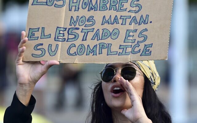 Une femme tient une pancarte o l'on peut lire « Les hommes nous tuent, l'État les accompagne » lors de la Journée internationale pour l'élimination de la violence à l'égard des femmes, à Panama, le 25 novembre 2019. (Crédit : Luis ACOSTA / AFP)