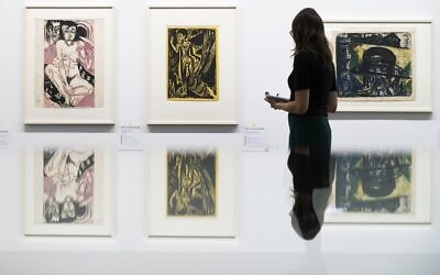 Une visiteuse regarde les peintures "Melancholisches Maedchen", à gauche, et Nackte Frau im Walde" du peintre allemand  Ernst Ludwig Kirchner, dans l'exposition ‘Rapport de statut Gurlitt. Art dégénéré - confisqué et vendu' organisée au Kunstmuseum de Bern, en Suisse, le 1er novembre 2017 (Crédit : Peter Klaunzer/Keystone via AP)