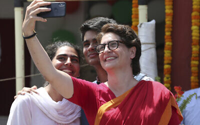La secrétaire-générale du parti du Congrès Priyanka Vadra, en rouge, prend un selfie avec ses enfants à Amethi, dans l'Etat d'Uttar Pradesh, en Inde, le 10 avril 2019 (Crédit :  AP Photo/Rajesh Kumar Singh)