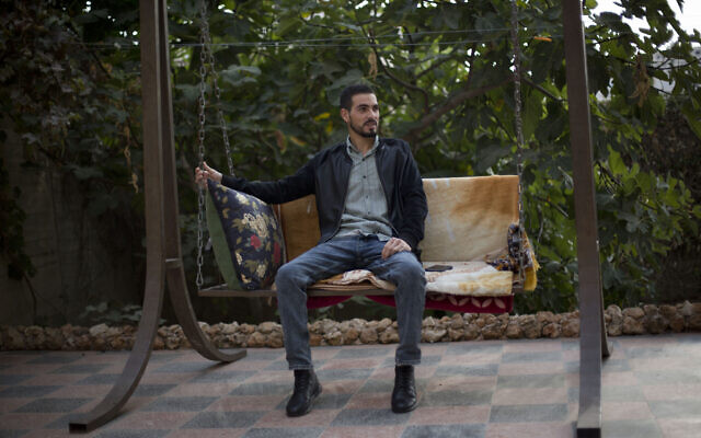 Le Palestinien Karam Qawasmi, qui a été blessé dans le dos par balle par les forces israéliennes lors d'un incident filmé l'an dernier, est assis dans son jardin, à Hébron, en Cisjordanie, le dimanche 10 novembre 2019. (AP Photo/Majdi Mohammed)