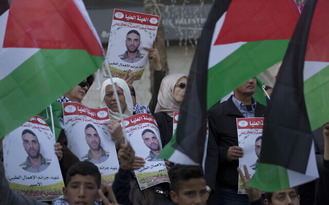 Des manifestants agitent des panneaux à l'effigie de Sami Abu Diak, un terroriste palestinien décédé d'un cancer dans les prisons israéliennes, durant une manifestation à Ramallah, le 26 novembre 2019. (Crédit : AP Photo/Nasser Nasser) Des manifestants agitent des panneaux à l'effigie de Sami Abu Diak, un terroriste palestinien décédé d'un cancer dans les prisons israéliennes, durant une manifestation à Ramallah, le 26 novembre 2019. (Crédit : AP Photo/Nasser Nasser)