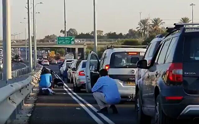 Des automobilistes israéliens s'accroupissent pendant qu'une sirène d'alarme retentit sur l'autoroute, le 12 novembre 2019. (Crédit : Twitter) Des automobilistes israéliens s'accroupissent pendant qu'une sirène d'alarme retentit sur l'autoroute, le 12 novembre 2019. (Crédit : Twitter)