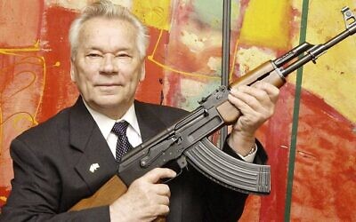 Le concepteur d'armes russe Mikhail Kalachnikov présente aux médias son fusil d'assaut légendaire lors de l'ouverture de l'exposition "Kalachnikov - légende et malédiction d'une arme" dans un musée de l'armement à Suhl, en Allemagne, le 26 juillet 2002. (AP / Jens Meyer)
