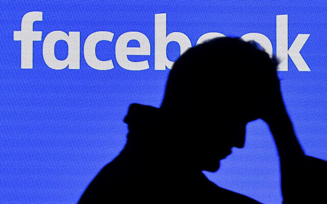 Illustration  un homme devant un écran de Facebook au Gamescom à Cologne, en Allemagne, le 20 août 2019. (Crédit : AP Photo/Martin Meissner)