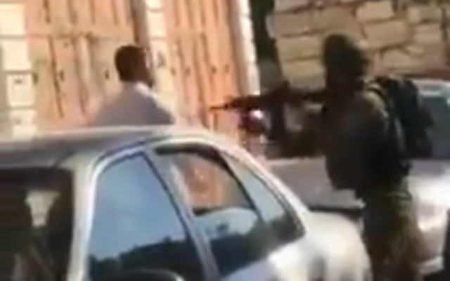Un soldat de l'armée dirige son arme vers un Palestinien devant son enfant à Hébron, le 5 novembre 2019 (Capture d'écran : Twitter)