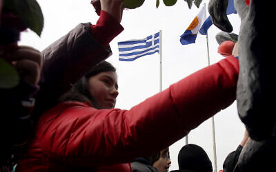 Photo d'illustration : Des enfants mettent des fleurs sur un site de commémoration de la Shoah en souvenir des persécutions des Juifs pendant la Seconde guerre mondiale à Thessalonique, en Grèce, le 27 janvier 2013 (Crédit : AP Photo/Nikolas Giakoumidis)
