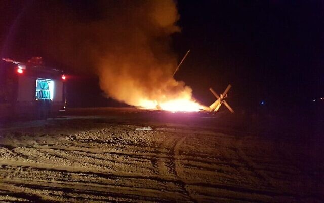 Des pompiers travaillent sur un hélicoptère en feu, près de Rahat dans le désert du Négev, le 26 novembre 2019. (Crédit : sapeurs-pompiers)