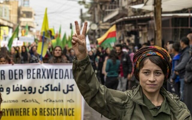 Une membre des Forces de sécurité interne kurde d'Asayesh fait le signe du V de la victoire lors d'une manifestation contre les menaces turques dans la ville du nord-est de Qamishli, la capitale de-facto de la minorité kurde en Syrie, le 2 novembre 2019.  (Photo par Delil SOULEIMAN / AFP)