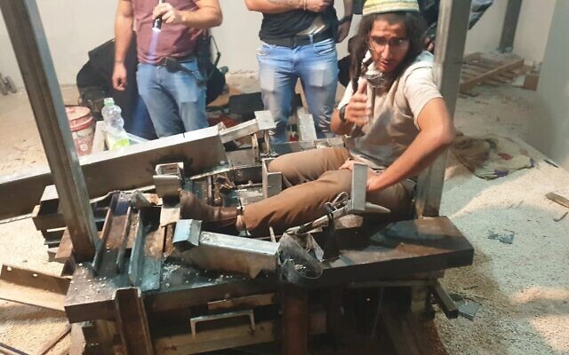 Neria Zarog s'attache à une scie circulaire à 
Yitzhar pour éviter d'être arrêté pour avoir enfreint un ordre administratif, le 10 novembre 2019. (Crédit : Honenu)