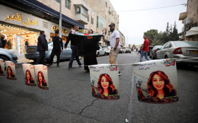 Des Palestiniens accrochent des photos de  Heba al-Labadi, citoyenne jordanienne d'origine palestinienne, au cours d'une manifestation demandant sa libération à Jérusalem-Est, le 26 octobre 2019 (Crédit : AP/Mahmoud Illean)