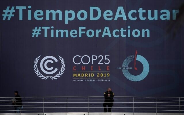 Un garde de sécurité devant la banderole du sommet COP25 sur le climat "Time for Action", au centre de conférence IFEMA de Madrid, le 30 novembre 2019, où le sommet se tiendra du 2 au 13 décembre 2019. (Crédit : Pierre-Philippe Marcou/AFP) Un garde de sécurité devant la banderole du sommet COP25 sur le climat "Time for Action", au centre de conférence IFEMA de Madrid, le 30 novembre 2019, où le sommet se tiendra du 2 au 13 décembre 2019. (Crédit : Pierre-Philippe Marcou/AFP)