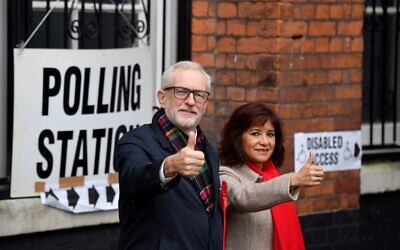 Le leader du parti Travailliste britannique Jeremy Corbyn et son épouse Laura Alvarez posent à leur arrivée à un bureau de vote dans le nord de Londres, le 12 décembre 2019, alors que la Grande-Bretagne vote pour ses élections générales (Crédit : DANIEL LEAL-OLIVAS / AFP)
