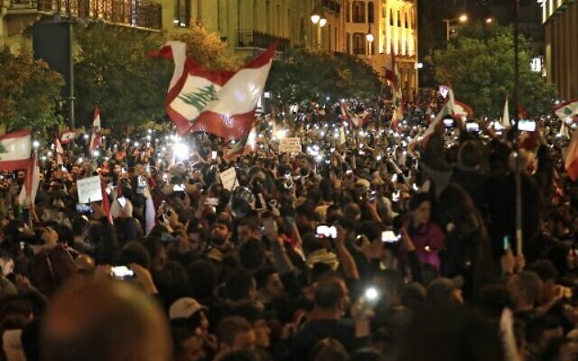 Des manifestants libanais brandissent le drapeau national pendant une manifestation anti-gouvernementale dans le centre-ville de la capitale Beyrouth, le 15 décembre 2019. (Crédit : ANWAR AMRO / AFP) Des manifestants libanais brandissent le drapeau national pendant une manifestation anti-gouvernementale dans le centre-ville de la capitale Beyrouth, le 15 décembre 2019. (Crédit : ANWAR AMRO / AFP)