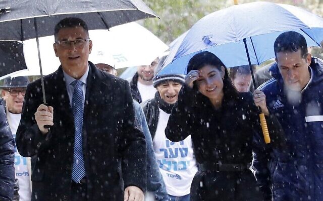 Gideon Sa'ar (L), Israeli Member of Knesset for Likud, accompanied by his wife Geula Even Sa'ar (R), arrive to cast his ballot during a primary election vote to elect the party chairman, in the Israeli coastal city of Tel Aviv, on December 26, 2019. - Sa'ar is the only challenger for incumbent Prime Minister Benjamin Netanyahu for the Likud party leadership ahead of the scheduled general elections in 2020. (Photo by JACK GUEZ / AFP)