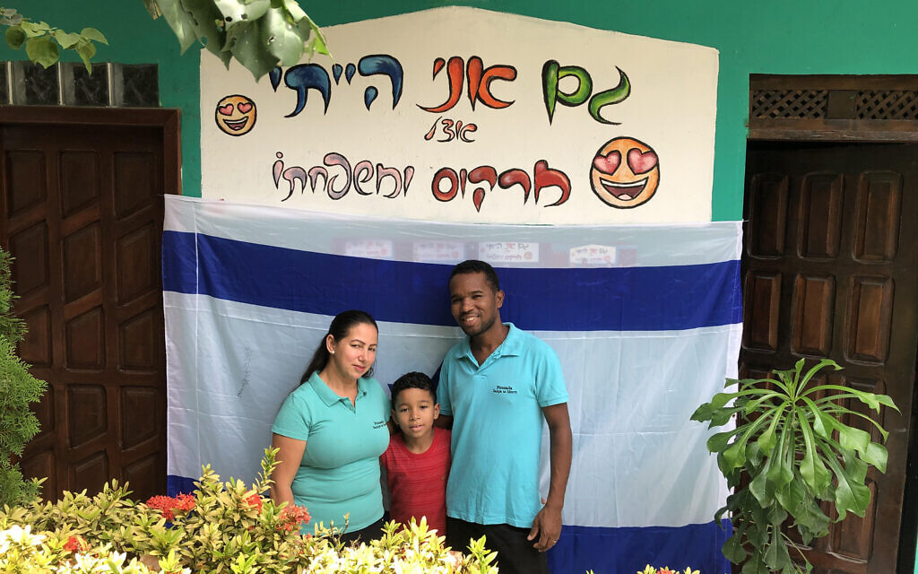La famille Santos pose à l'endroit où l'on peut lire sur la photo : "J'étais aussi avec Marcos et sa famille", à l'hôtel Sampa no Morro. (Marcus Gilban/JTA)