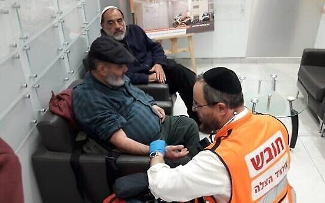 Un urgentiste examine David Ben Avraham (au centre) après sa libération de la prison palestinienne, en présence de son amis Haim Parag. (Crédit : Hatzala)