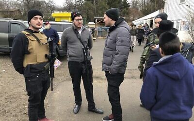 Des membres armés de la communauté juive montent la garde lors d'une célébration, le dimanche 29 décembre 2019, à Monsey, N.Y. Un jour auparavant, un homme armé d'un couteau avait fait irruption dans la maison d'un rabbin et avait poignardé plusieurs personnes alors qu'elles célébraient Hanoukka dans la communauté juive orthodoxe. (AP Photo/Ted Shaffrey)