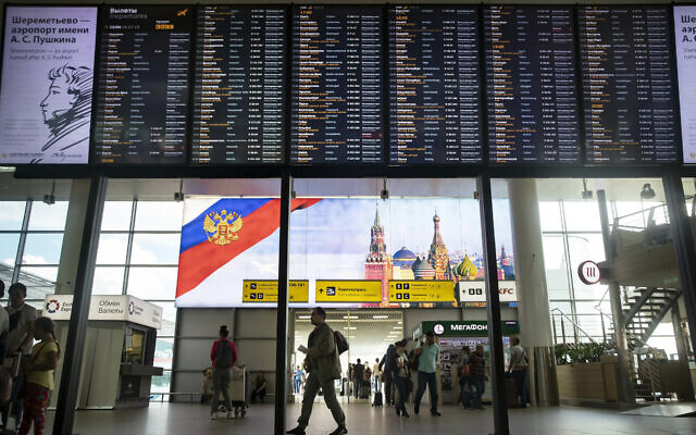 Des passagers devant un panneau de départ à l'aéroport international Sheremetyevo de Moscou, Russie, le 8 juillet 2019. (Crédit : AP/Pavel Golovkin) Des passagers devant un panneau de départ à l'aéroport international Sheremetyevo de Moscou, Russie, le 8 juillet 2019. (Crédit : AP/Pavel Golovkin)