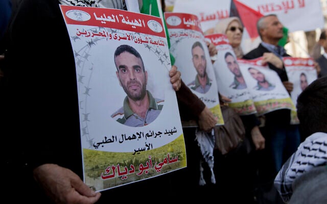 Des manifestants arborent des drapeaux palestiniens et des affiches avec des photos du terroriste Sami Abu Diak, à Ramallah, en Cisjordanie, le 26 novembre 2019. (AP Photo/Nasser Nasser) Des manifestants arborent des drapeaux palestiniens et des affiches avec des photos du terroriste Sami Abu Diak, à Ramallah, en Cisjordanie, le 26 novembre 2019. (AP Photo/Nasser Nasser)