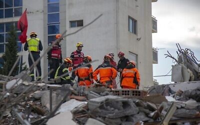 Des équipes de sauvetage de France et de Suisse travaillent sur les ruines d'un immeuble après un séisme à Durres, en Albanie, le 29 novembre 2019. (Crédit : AP Photo/Visar Kryeziu)