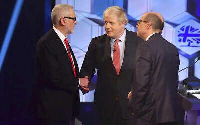 Le chef du parti travailliste de l'opposition Jeremy Corbyn, à gauche, serre la main du premier ministre britannique Boris Johnson, au centre, avec l'animateur du débat Nick Robinson, à droite, lors d'un débat en direct sur les élections aux studios de la BBC à Maidstone, Angleterre, le 6 décembre 2019 (Crédit : Jeff Overs/BBC via AP) Le chef du parti travailliste de l'opposition Jeremy Corbyn, à gauche, serre la main du premier ministre britannique Boris Johnson, au centre, avec l'animateur du débat Nick Robinson, à droite, lors d'un débat en direct sur les élections aux studios de la BBC à Maidstone, Angleterre, le 6 décembre 2019 (Crédit : Jeff Overs/BBC via AP)