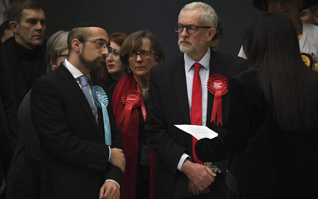 Le chef du Parti travailliste de l'opposition britannique Jeremy Corbyn, à droite, attend la déclaration de son siège aux élections générales de 2019 à Islington, Londres, le 13 décembre 2019 (Crédit : AP Photo/Alberto Pezzali). Le chef du Parti travailliste de l'opposition britannique Jeremy Corbyn, à droite, attend la déclaration de son siège aux élections générales de 2019 à Islington, Londres, le 13 décembre 2019 (Crédit : AP Photo/Alberto Pezzali).