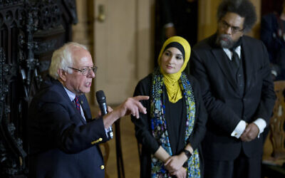 Linda Sarsour, (au centre) et Cornel West, (à droite), écoutent le candidat démocrate à la présidentielle Bernie Sanders, indépendant du Vermont, lors d'une table ronde au sein de la Congregational Society, à Brooklyn, à New York, le 16 avril 2016 (Crédit : AP Photo/Mary Altaffer)