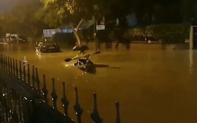 Des gens pagaient sur une route inondée dans la ville d'Ashkelon, dans le sud d'Israël, le 
12 décembre 2019 (Capture d'écran YouTube)