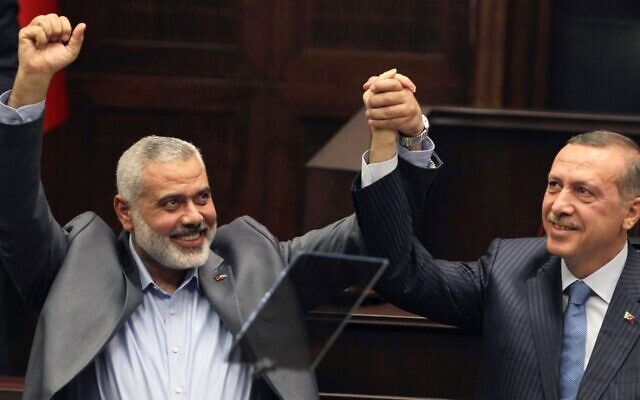Ismail Haniyeh, le chef du Hamas dans la bande de Gaza, à gauche, et son homologue turc Recep Tayyip Erdogan saluent les élus et soutiens du parti islamique de la Justice et du Développement d'Ergodan au parlement à Ankara, en Turquie, el 3 janvier 2012. (Crédit photo : AP)