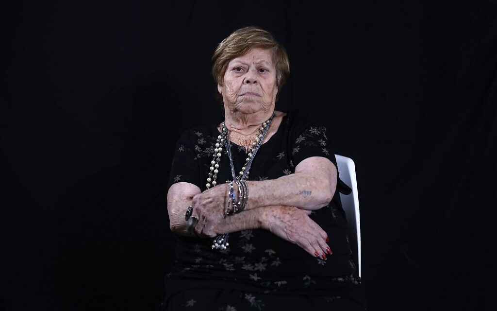 La survivante de la Shoah Malka Zaken, 91 ans, montre sa matricule 76979, à son domicile de Tel Aviv, le 16 décembre 2019. (Crédit :MENAHEM KAHANA / AFP)