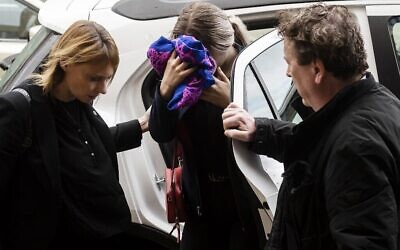 Une adolescente britannique accusée d'avoir prétendu à tort avoir été violée par des touristes israéliens, se couvre le visage alors qu'elle arrive pour son procès devant le tribunal de district de Famagouste à Paralimni, dans l'est de Chypre, le 30 décembre 2019. (Crédit : Iakovos Hatzistavrou / AFP) Une adolescente britannique accusée d'avoir prétendu à tort avoir été violée par des touristes israéliens, se couvre le visage alors qu'elle arrive pour son procès devant le tribunal de district de Famagouste à Paralimni, dans l'est de Chypre, le 30 décembre 2019. (Crédit : Iakovos Hatzistavrou / AFP)
