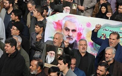 Des Iraniens défilent avec une bannière portant la photo du général Qassem Soleimani, chef des forces al-Quads, lors d'une manifestation après la mort de ce dernier organisée à Téhéran, le 3 janvier 2020 (Crédit : Atta Kenare/AFP) Des Iraniens défilent avec une bannière portant la photo du général Qassem Soleimani, chef des forces al-Quads, lors d'une manifestation après la mort de ce dernier organisée à Téhéran, le 3 janvier 2020 (Crédit : Atta Kenare/AFP)