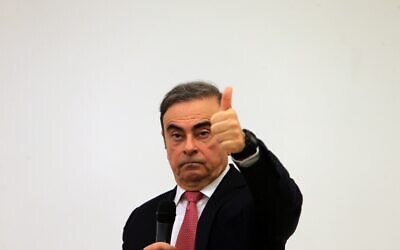 L'ancien PDG de Renalt Nissan Carlos Ghosn fait un signe de la main alors qu'il s'exprime à une foule de journalistes pour expliquer sa fuite devant la justice nippone, où il est accusé de malversations financières, au syndicat de la presse libanais, à Beyrouth, le 8 janvier 2020. 
(Photo by - / AFP)