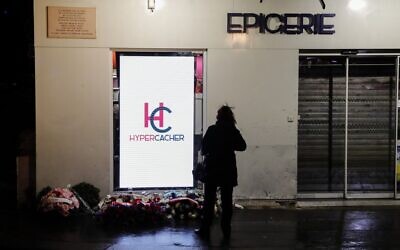 Une femme se tient devant le supermarché casher Hyper Cacher dans le sud-ouest de Paris le 9 janvier 2020 lors d'une cérémonie commémorative cinq ans après une prise d'otage mortelle par un homme armé djihadiste. (Crédit : Thomas SAMSON / AFP)