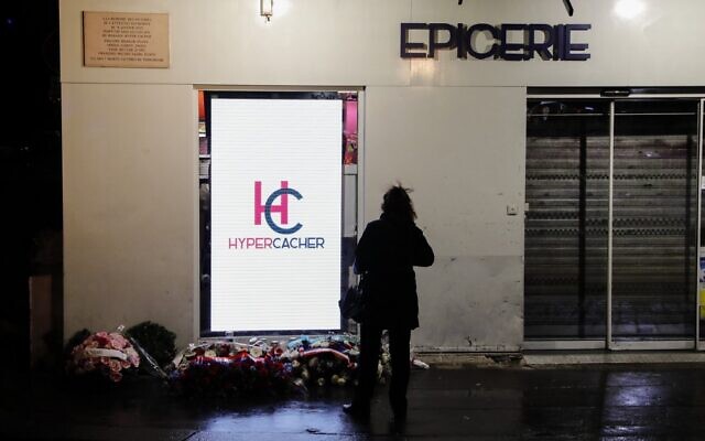 Une femme se tient devant le supermarché casher Hyper Cacher dans le sud-ouest de Paris le 9 janvier 2020 lors d'une cérémonie commémorative cinq ans après une prise d'otage mortelle par un homme armé djihadiste. (Crédit : Thomas SAMSON / AFP)
