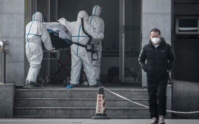Des membres du personnel médical transportant un patient à l'hôpital de Jinyintan, où sont soignés des patients infectés par un mystérieux virus de type SRAS, à Wuhan, dans la province centrale du Hubei, en Chine, le 18 janvier 2020. (AFP)
