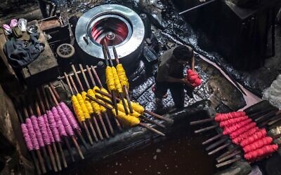 Des ouvriers teignent des fils dans un atelier traditionnel de teinture à la main dans le quartier séculaire de Darb al-Ahmar, au Caire, la capitale égyptienne, le 21 janvier 2020. (Crédit : Khaled DESOUKI / AFP)