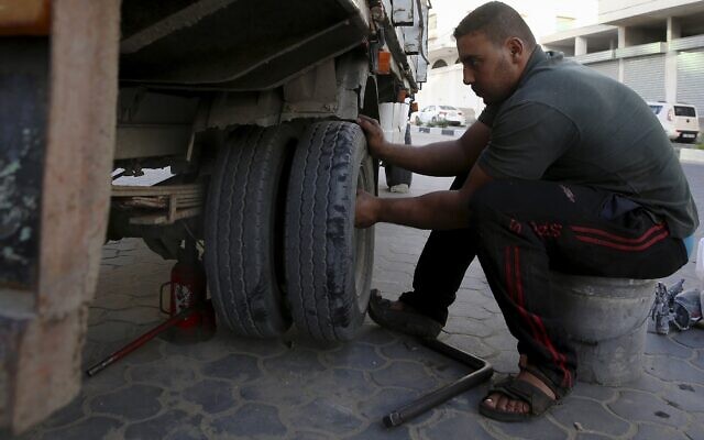 Un homme remplace un pneu dans un garage de Gaza City, le 30 octobre 2018. (Crédit : AP Photo/Adel Hana)