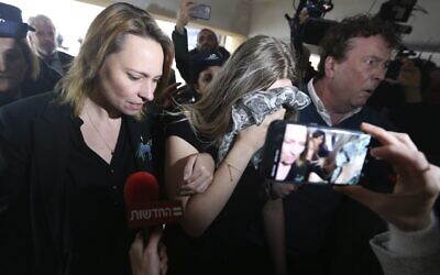 Une femme britannique de 19 ans, au centre, reconnue coupable d'avoir inventé des allégations selon lesquelles elle aurait été violée par 12 Israéliens arrive au tribunal de district de Famagouste pour y être condamnée le 7 janvier 2020 (Crédit : AP Photo/Petros Karadjias)