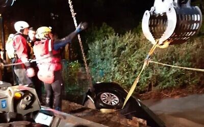 Des secouristes extraient une voiture des eaux, à Binyamina. (Crédit : Fire and Rescue Service)